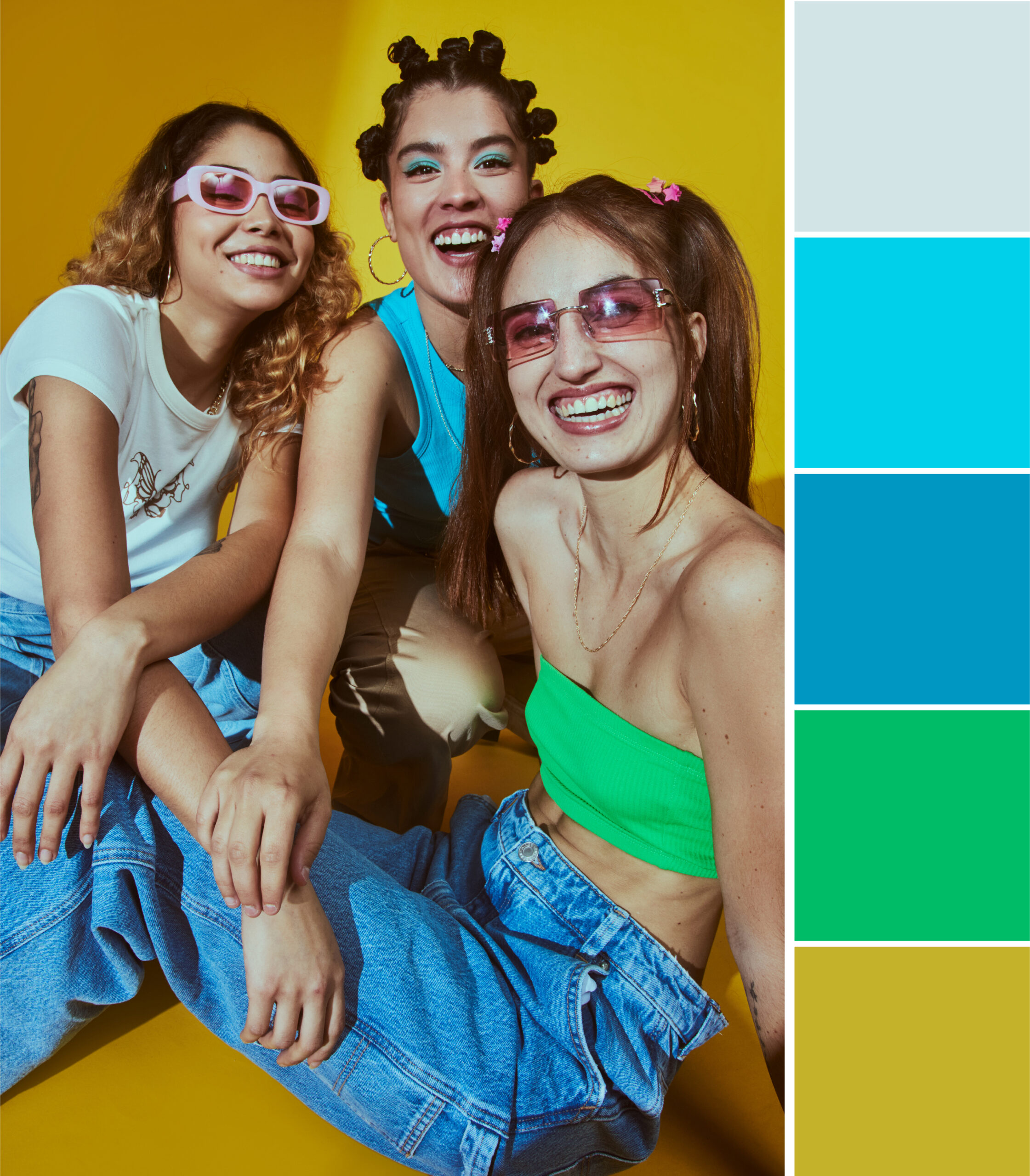 Three young women wearing trendy colorful sunglasses and vibrant outfits pose against a bright yellow background, showcasing bold eyewear and 2025 fashion color trends.